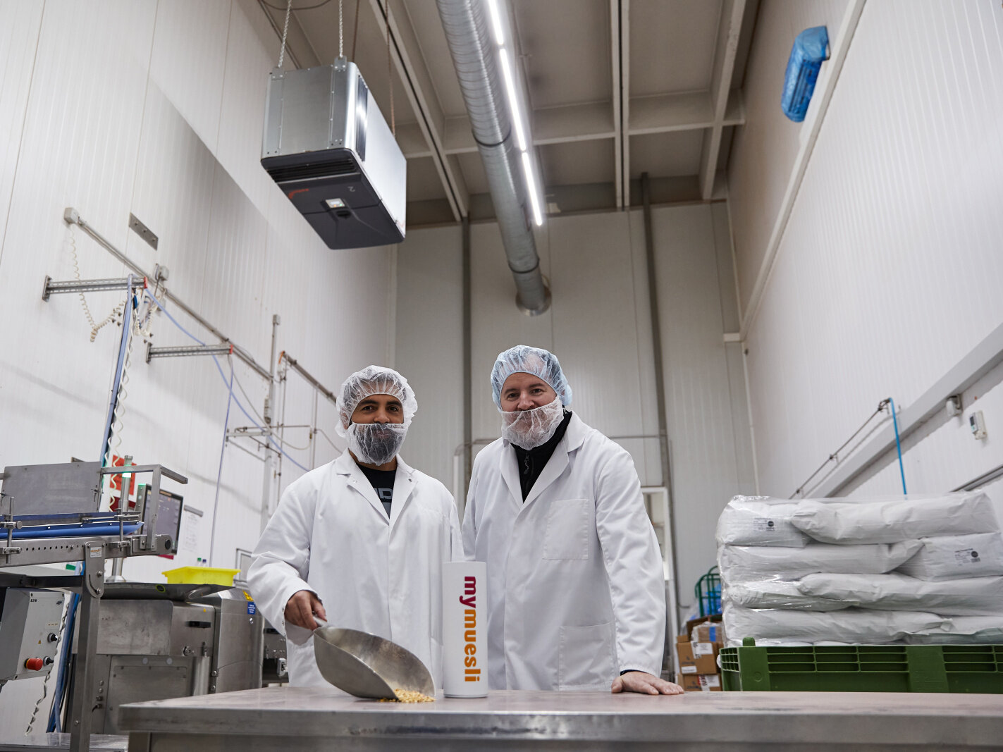 zwi männer in klninischen anzügen arbeiten in produktionshalle