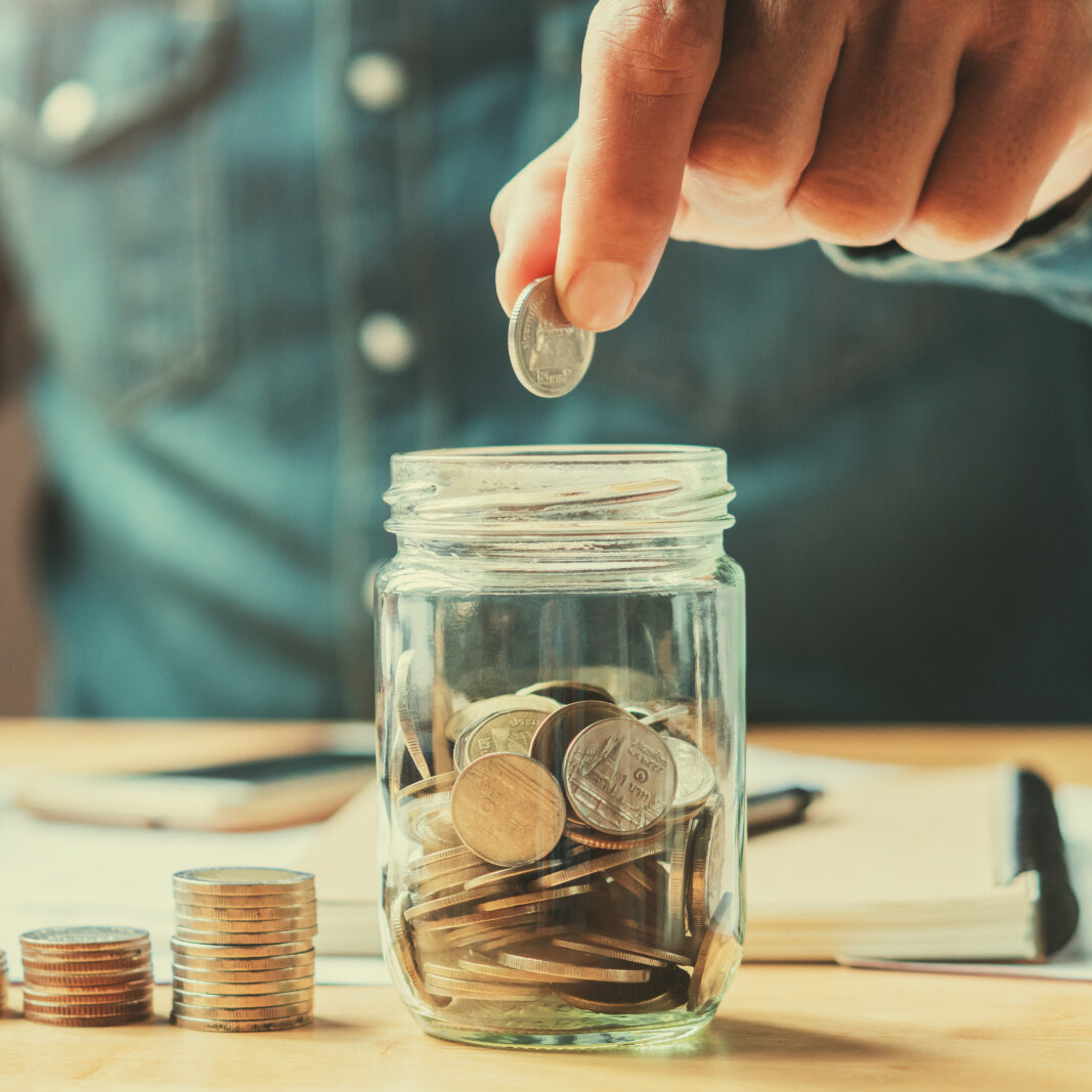 businessman holding coins putting in glass. concept saving money for finance accounting